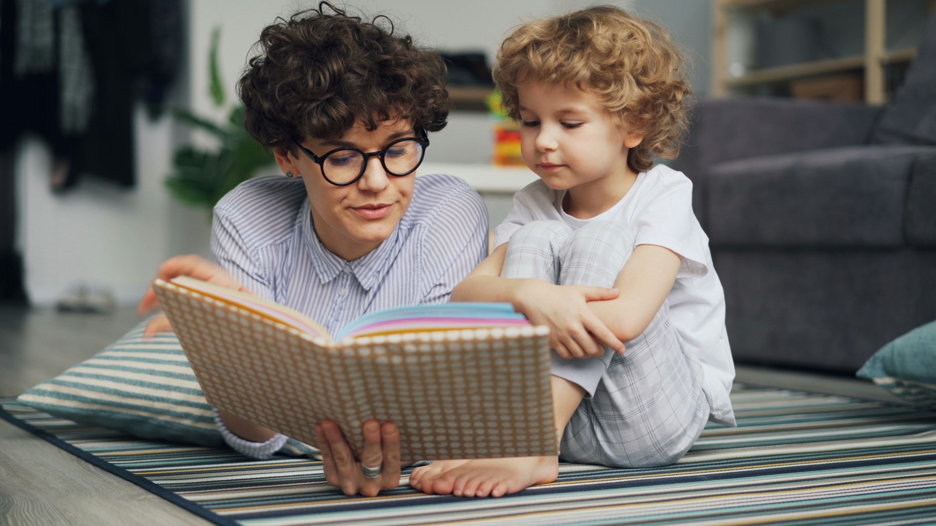 A teacher reading with a young pupil