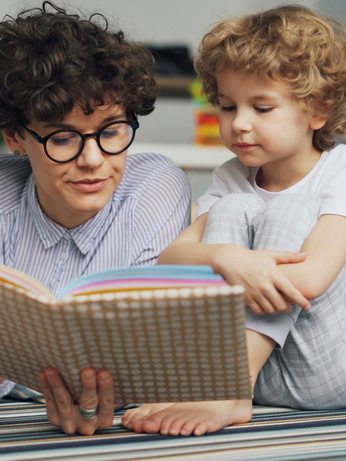A teacher reading with a young pupil